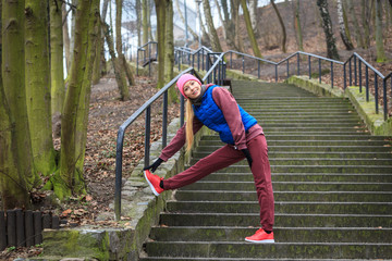 Fototapeta premium Woman wearing sportswear exercising outside during autumn