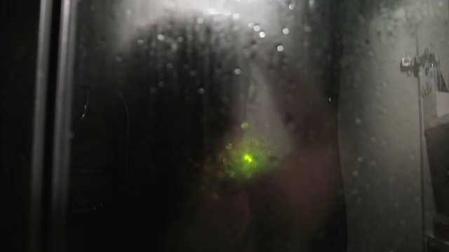 Sexy woman silhouette behind wet glass. Naked girl silhouette behind wet glass in shower. Female body silhouette behind wet glass in shower. Naked woman in shower