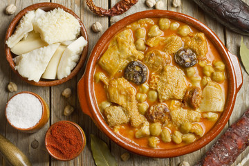 Spanish callos with chickpeas and ingredients on a wooden table