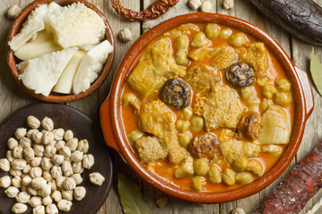 Spanish callos with chickpeas and ingredients on a wooden table