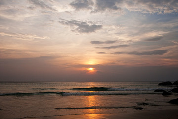 The evening sun sets in the clouds on the horizon