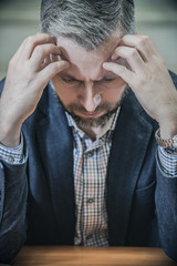 distressed sad businessman sitting in despair in the office
