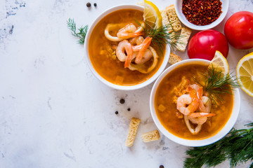 Lentil soup with seafood. Red soup with shrimps and squid