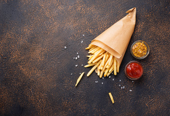 French fries in a paper bag with sauces