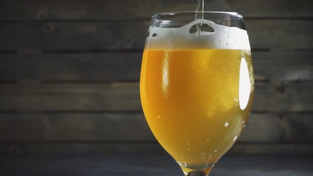 Pouring light beer into glass.
