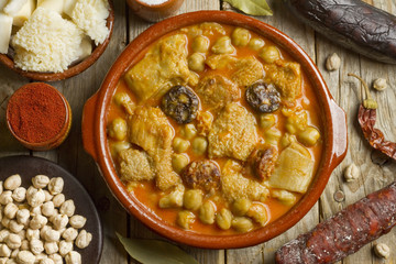 Spanish callos with chickpeas and ingredients on a wooden table