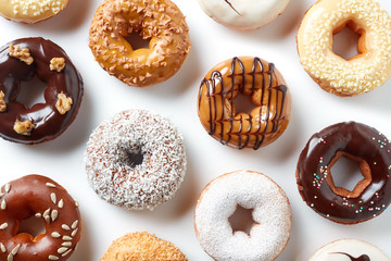 Various donuts isolated on white, from above