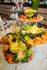 Fruit assortment of peaches, pineapples and grapes on banquet table