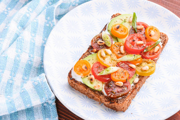 bruschetta with avocado, cherry tomatoes, blue cheese sauce, shallots. concept of a healthy breakfast