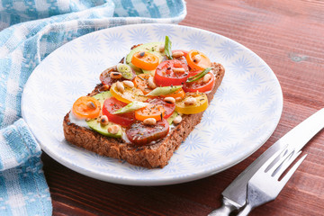 bruschetta with avocado, cherry tomatoes, blue cheese sauce, shallots. concept of a healthy breakfast