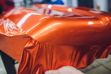 Car wrapping specialist putting vinyl foil or film on car wrapping protective film yacht, boat,...