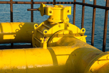 yellow pipeline with pump in cage on sea background