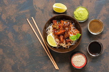 Glass noodles with vegetables and meat. Korean dish, top view. Stir-Fred Pork. Rustic rusty background, copy space.