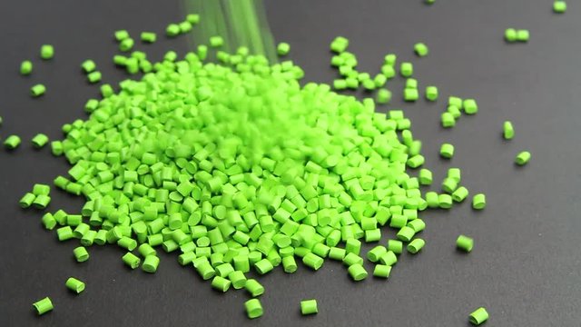 Plastic pellets crumbles to the table . Plastic raw materials in granules for industry. Polymer resin.