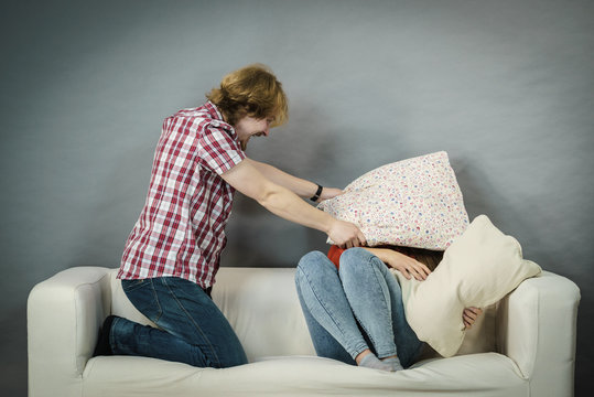 Man and woman having pillow fight.