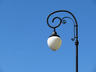 Fototapeta na wymiar Vintage street lamp on the background of clear blue sky. Lamp post isolated, decorated lantern
