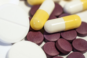 A handful of white, purple and yellow tablets