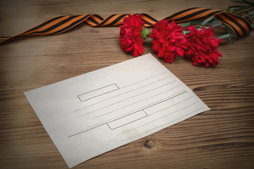 9 nine may Victory day concept background. The Great Patriotic War. Letter from the front. Saint George ribbon, red carnation flowers and red star medals with letter...