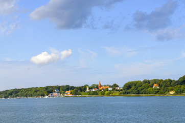 Fototapeta na wymiar View from the Ruegen bridge to the coast of the island Rügen with the village of Altefaehr