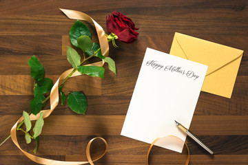 table with mothers day card with red rose