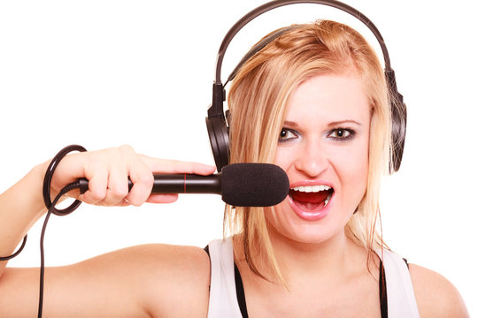 Woman singing to microphone wearing headphones