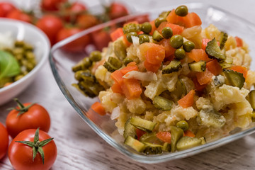 tasty potato salad in mycelium laid on the table, ingredients in lettuce - potatoes majneza carrot cucumbers traditional Slovak peas