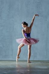 Young beautiful ballerina is posing in studio