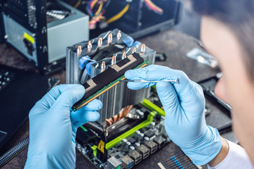 Engineer technician computers in gloves on the hands is reviewing the failure. Concept of repair microchip