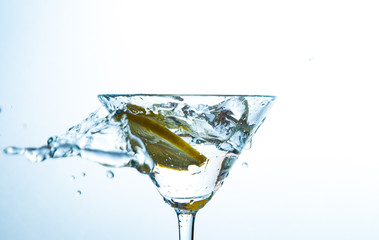 Glass of water with lemon with splash with copy space on white