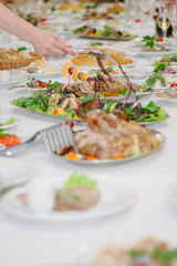 Catering table - hand with tongs taking a food.