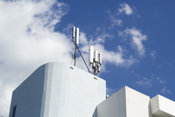 Smart cellular network antenna base station on the telecommunication mast on the roof of the building. 3G. 4G. 5G. Telecommunication mast television antennas.