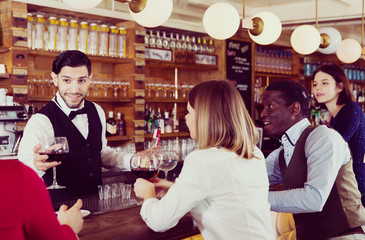 Young people are relaxing near bar counter and drinking alcohol