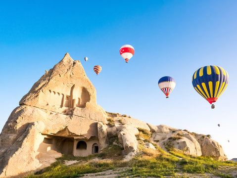 Colorful hot air balloons flying over rock landscape at Cappadocia Turkey