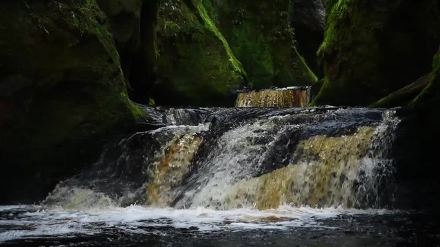 full view of the waterfalls running through the devils pulpit gorge in scotland.shot in slow motion