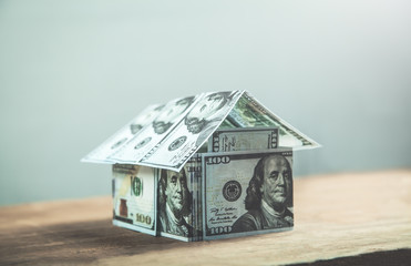 House of dollars on a wooden background.