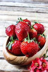 ripe strawberries in a wooden bowl on the table