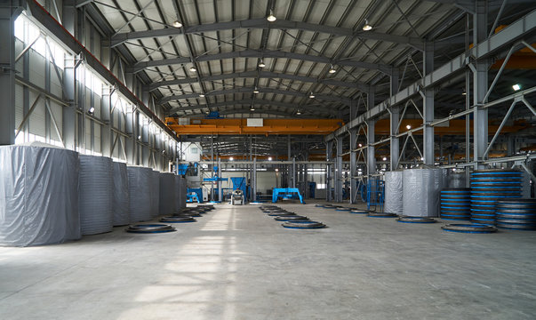 Modern large factory warehouse interior with some goods concrete pipes. Industrial production of cement products. Industry manufacturing concept