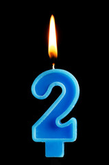 Burning birthday candle in the form of 2 two figures for cake isolated on black background. The concept of celebrating a birthday, anniversary, important date, holiday, table setting