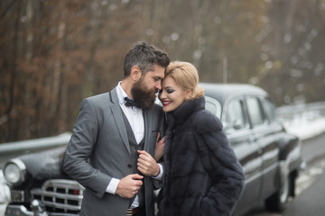 Couple at a retro or vintage car outdoor.