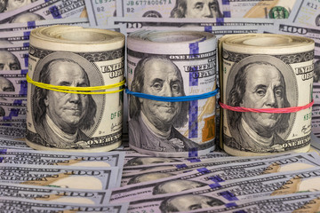 hundred dollar bills, background. three bundles of dollars are collected with colored rubber bands. I do not see anything, I hear nothing, I will not tell anyone.