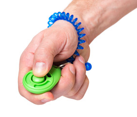 Man hand holding dog clicker - positive reinforcement training tool for dogs, isolated on white background. Clicker used for animal training.