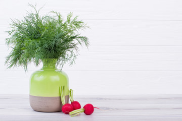 Bouquet of fresh dill in vase. Dill and radish on wooden table, copy space.