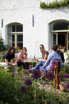 Group of friends drinking together on sunny terrace