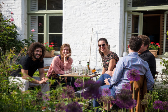 Group of friends drinking together on sunny terrace