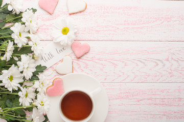 Tea with flowers and biscuits made with love. Top view with empty space for inscriptions