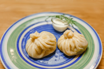Khinkali is Georgian dumplings on a plate with traditional matzoni sauce