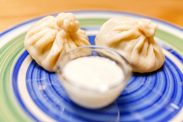 Khinkali is Georgian dumplings on a plate with traditional matzoni sauce