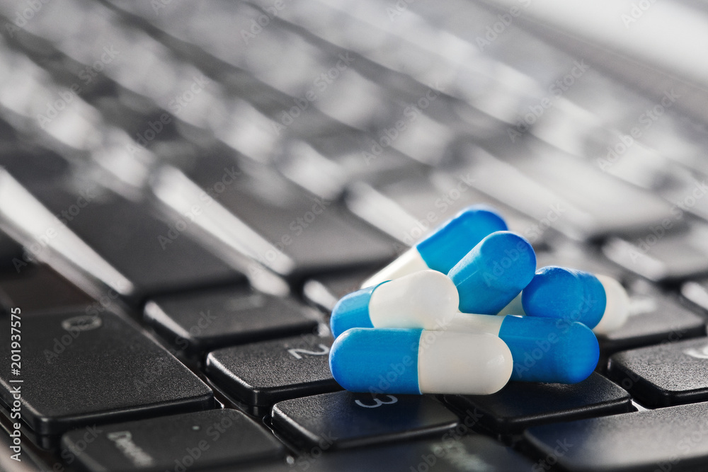 Wall mural heap of medical pills in blue color on computer keyboard. network security, data security and antivi