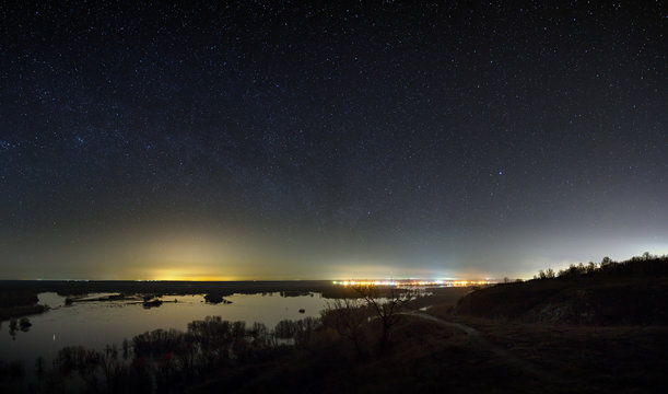 Sky with the stars in the landscape with a pond. Night landscape with a lake.