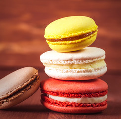 Stack of colorful macaroons on a wooden background